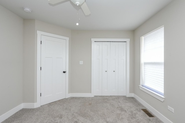 unfurnished bedroom featuring visible vents, baseboards, a closet, and carpet flooring