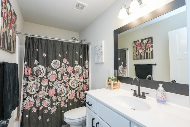 bathroom featuring visible vents, curtained shower, toilet, and vanity