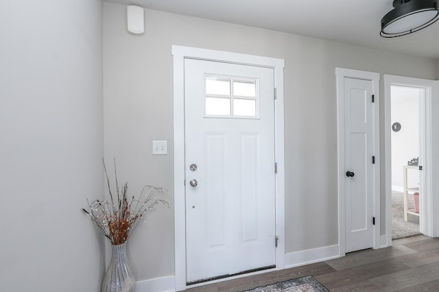 entryway featuring baseboards and wood finished floors
