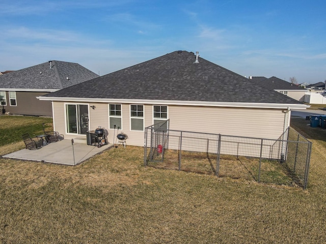 back of property with a patio, a yard, fence, and roof with shingles