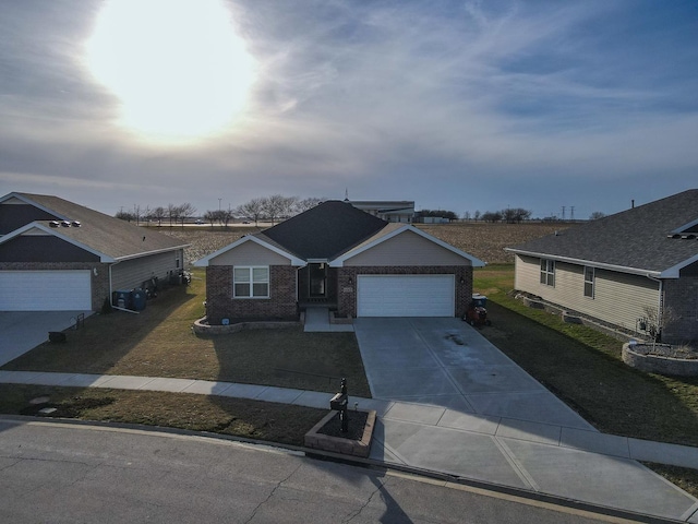 single story home with brick siding, a garage, a front yard, and driveway