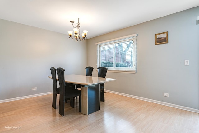 dining area featuring baseboards, a notable chandelier, and light wood-style flooring