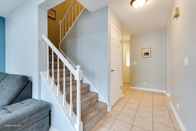 stairway with baseboards and tile patterned flooring