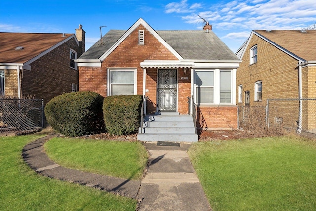 bungalow-style home featuring a front lawn, fence, and brick siding