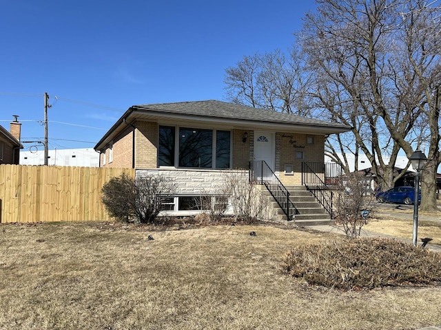 view of front of property with brick siding, roof with shingles, and fence