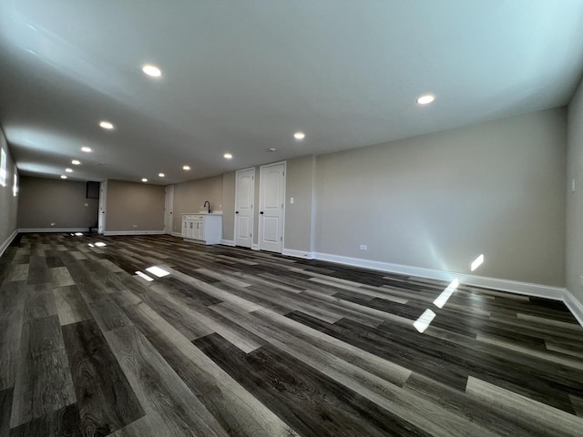 unfurnished living room with recessed lighting, baseboards, and dark wood finished floors