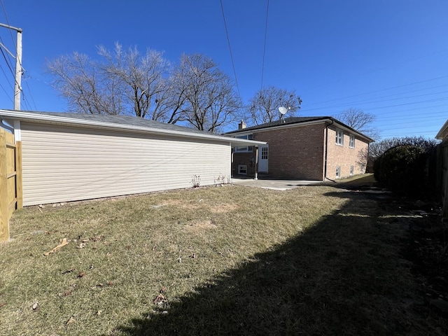 back of house featuring a patio, a lawn, brick siding, and fence