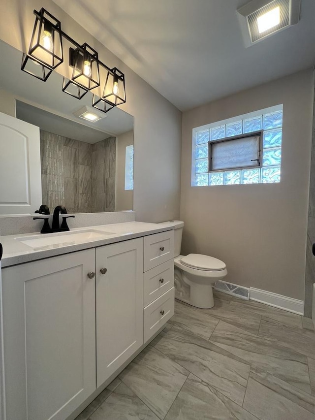 bathroom with vanity, toilet, visible vents, and marble finish floor