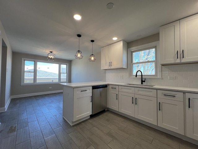 kitchen with wood tiled floor, a peninsula, stainless steel dishwasher, white cabinets, and a sink