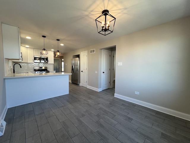 kitchen with visible vents, a sink, white cabinetry, appliances with stainless steel finishes, and decorative backsplash