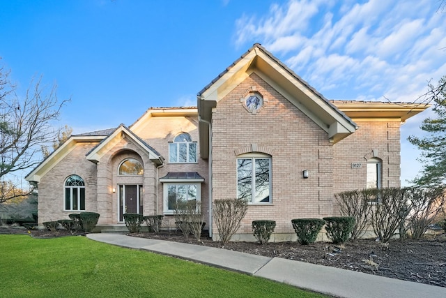 view of front of property with brick siding and a front yard