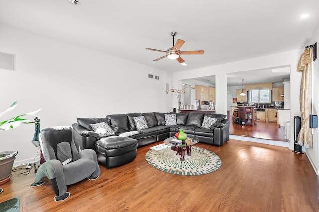 living room featuring a ceiling fan, wood finished floors, and visible vents