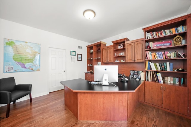 office space with visible vents, baseboards, and wood finished floors