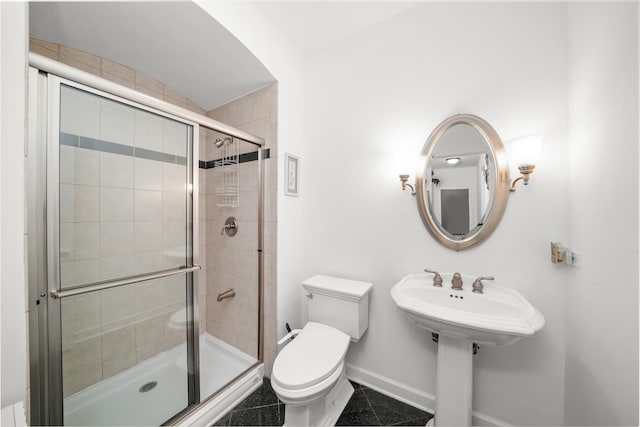 full bathroom featuring tile patterned flooring, a shower stall, toilet, and baseboards