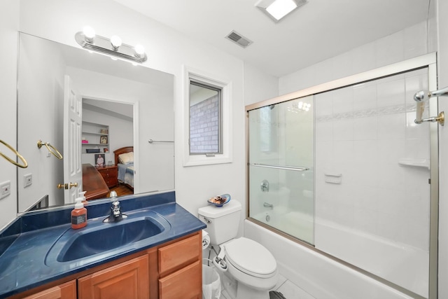 bathroom featuring visible vents, bath / shower combo with glass door, toilet, vanity, and ensuite bath