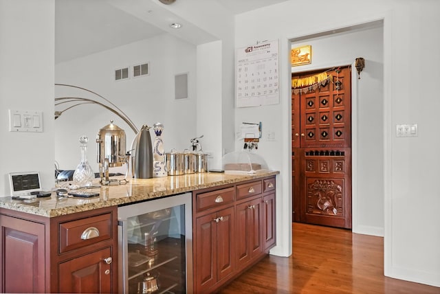 bar featuring wood finished floors, a dry bar, beverage cooler, and visible vents