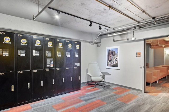 interior space featuring rail lighting and baseboards