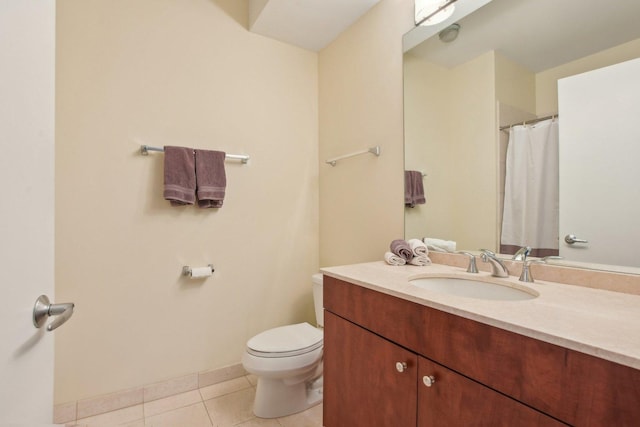 bathroom featuring tile patterned flooring, toilet, vanity, and baseboards