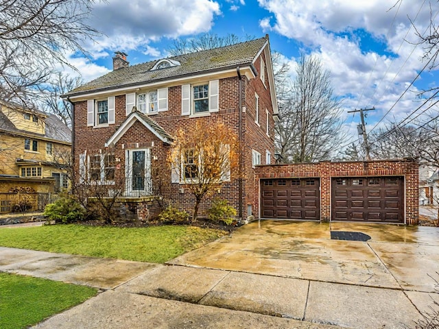 view of front of home featuring driveway, a front yard, brick siding, and a chimney