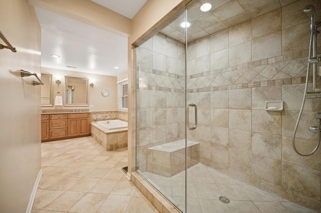 full bath with tile patterned floors, vanity, a garden tub, and a shower stall