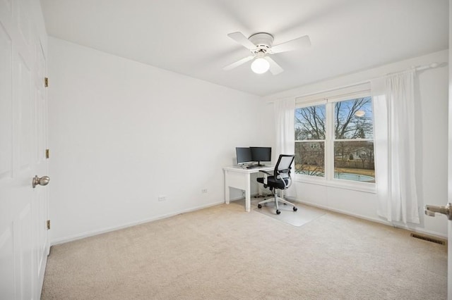 unfurnished office featuring visible vents, light carpet, baseboards, and ceiling fan