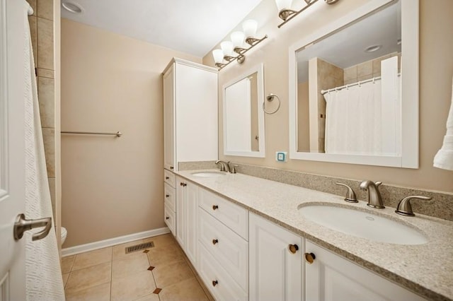 full bath featuring a sink, visible vents, double vanity, and tile patterned flooring