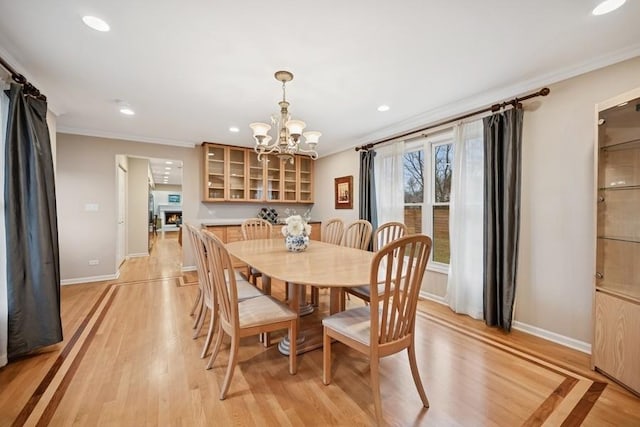 dining space with crown molding, light wood-style flooring, recessed lighting, and baseboards