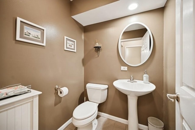 bathroom featuring baseboards, toilet, and tile patterned flooring