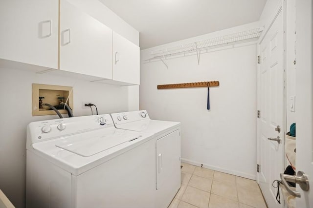 clothes washing area featuring light tile patterned floors, baseboards, cabinet space, and separate washer and dryer