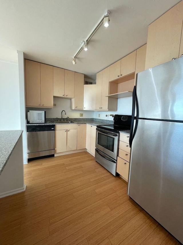 kitchen with visible vents, light wood-style flooring, stainless steel appliances, and a sink