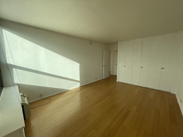 unfurnished bedroom featuring wood finished floors and baseboards