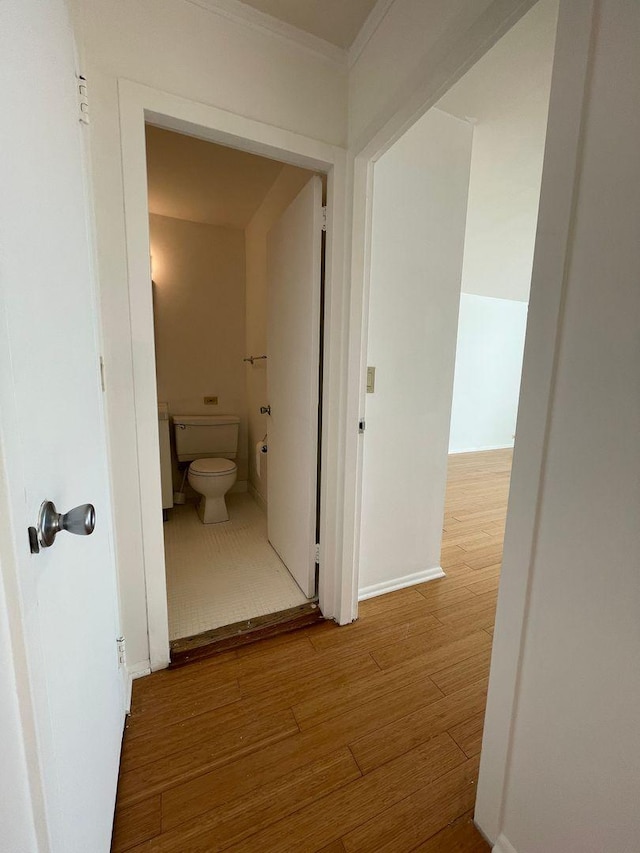 corridor featuring wood finished floors and baseboards