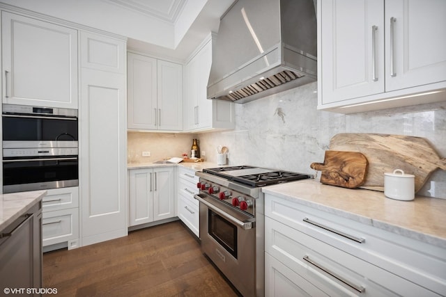 kitchen with dark wood-style floors, premium range hood, stainless steel appliances, white cabinetry, and backsplash