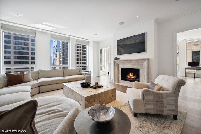 living room with recessed lighting, a premium fireplace, wood finished floors, and ornamental molding