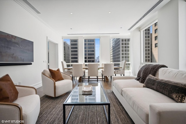 living room featuring crown molding, wood finished floors, baseboards, and expansive windows