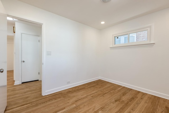 empty room with recessed lighting, light wood-type flooring, and baseboards