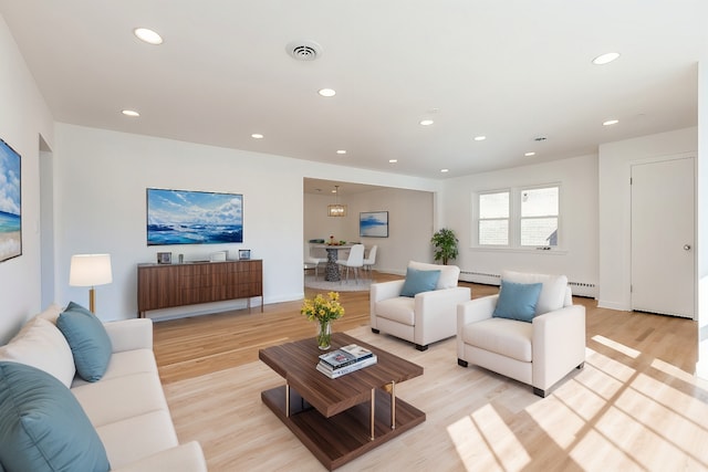 living room with light wood finished floors, baseboard heating, recessed lighting, and visible vents