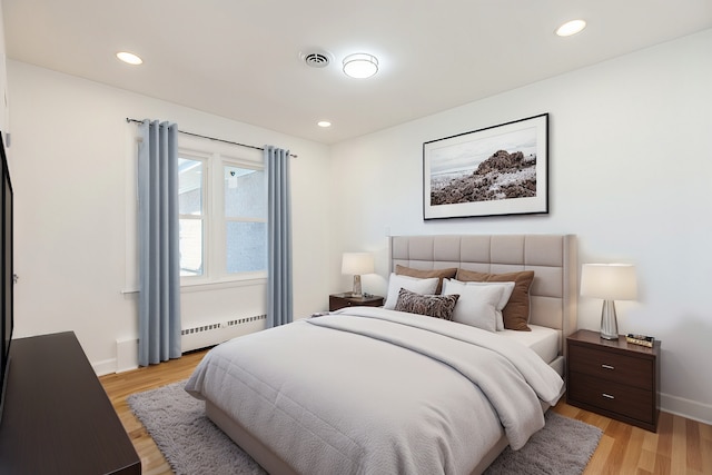 bedroom with visible vents, recessed lighting, a baseboard heating unit, and light wood-style floors