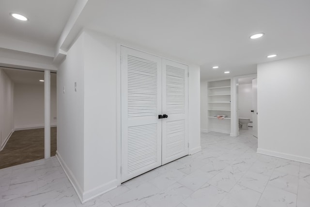 corridor with recessed lighting, built in features, baseboards, and marble finish floor