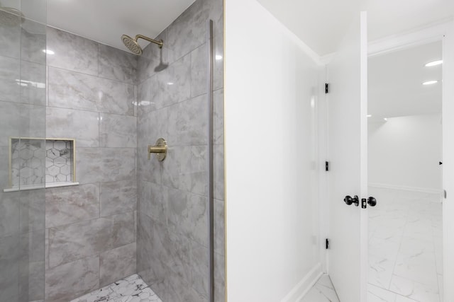 full bathroom with baseboards, marble finish floor, and a tile shower