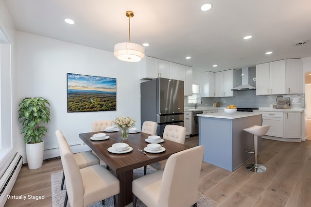 dining room with recessed lighting, a baseboard heating unit, light wood-style floors, and visible vents