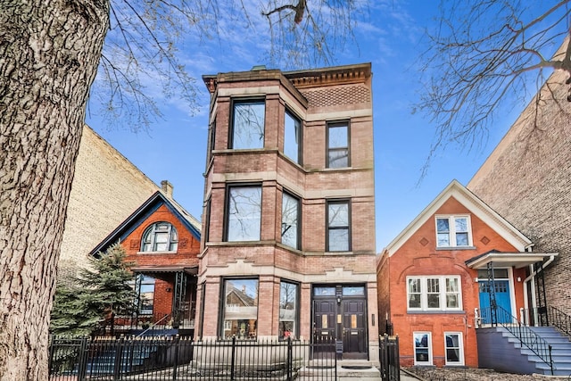 view of front of property featuring brick siding and a fenced front yard