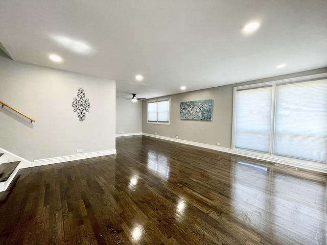 unfurnished living room featuring recessed lighting, baseboards, wood finished floors, and stairs