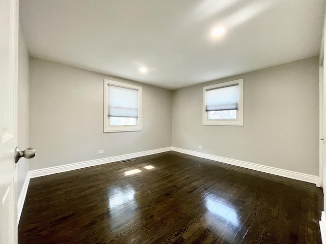 empty room with baseboards and dark wood-style flooring