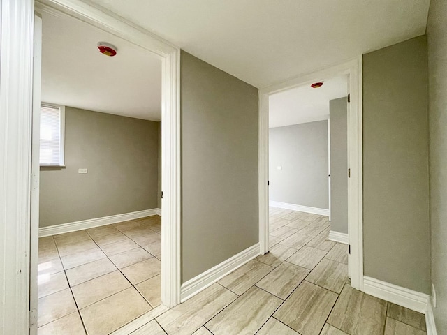 hall featuring baseboards and wood tiled floor