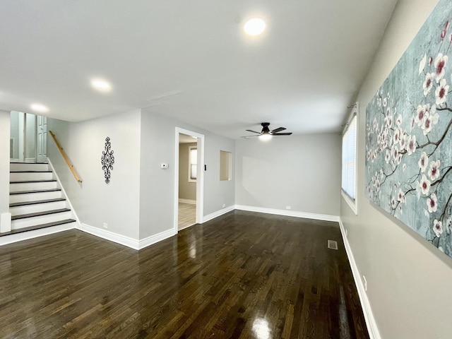 unfurnished living room with stairway, wood finished floors, visible vents, baseboards, and ceiling fan