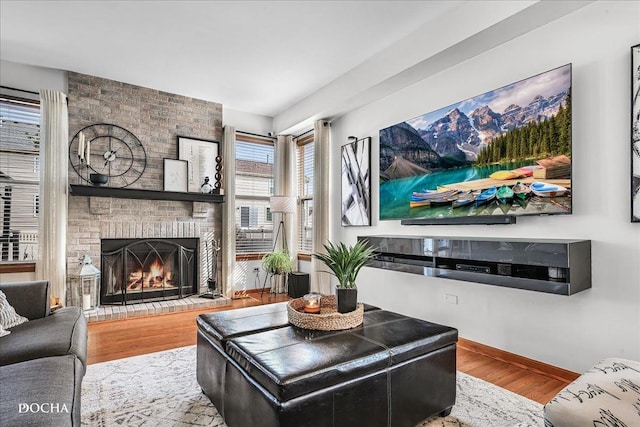 living area with a fireplace, wood finished floors, and baseboards