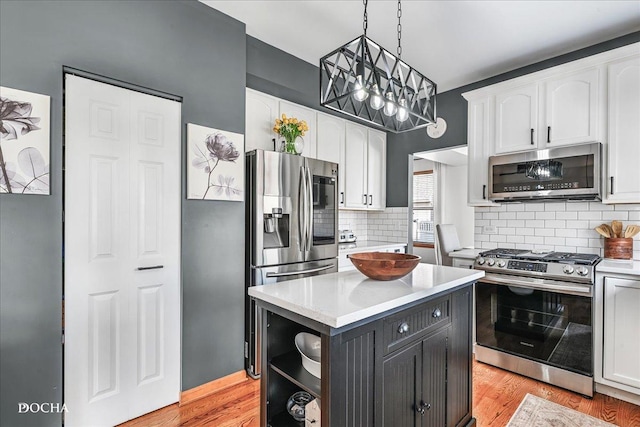 kitchen featuring a center island, light wood-type flooring, light countertops, white cabinets, and stainless steel appliances