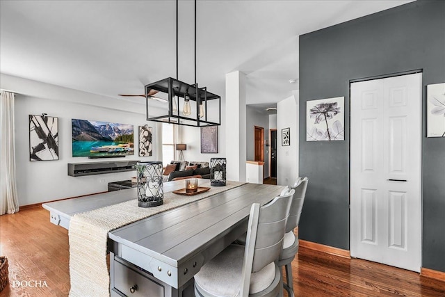 dining space with baseboards and wood finished floors