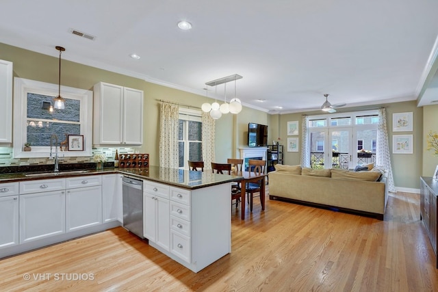 kitchen featuring stainless steel dishwasher, visible vents, light wood finished floors, and a sink